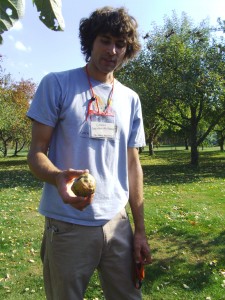 Colin Curwen-McAdams, orchard assistant at Seed Savers Exchange, displays an heirloom apple at the orchard near Decorah. (photo/Cindy Hadish)