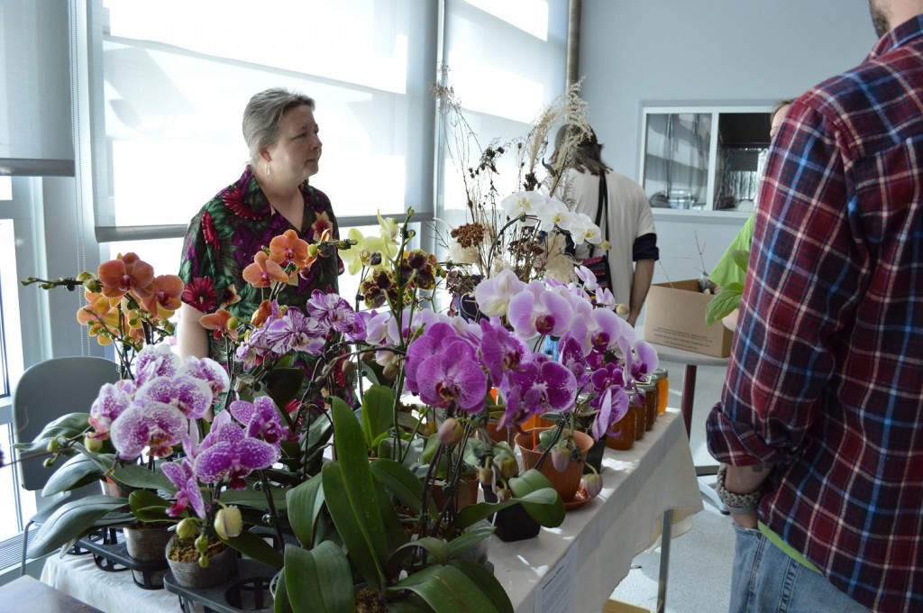 Joan Lorence of Solon talks to customers about orchids during the Backyard Abundance plant sale in Iowa City on Saturday, April 27, 2013. (photo/Cindy Hadish)
