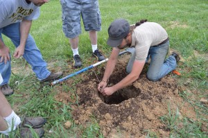 Kirkwood Community College instructor, Lucas McIntire, demonstrates how to plant a grapevine at the Kirkwood vineyard. (photo/Cindy Hadish)