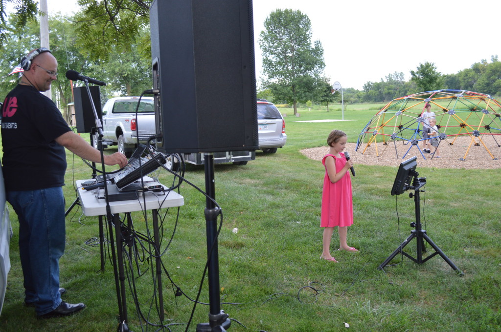 A young vocalist tries her hand at karaoke, provided by Unique Events, during the Oxford Farmers Market. The market provides bands and other entertainment each week on Monday nights. (photo/Cindy Hadish) 