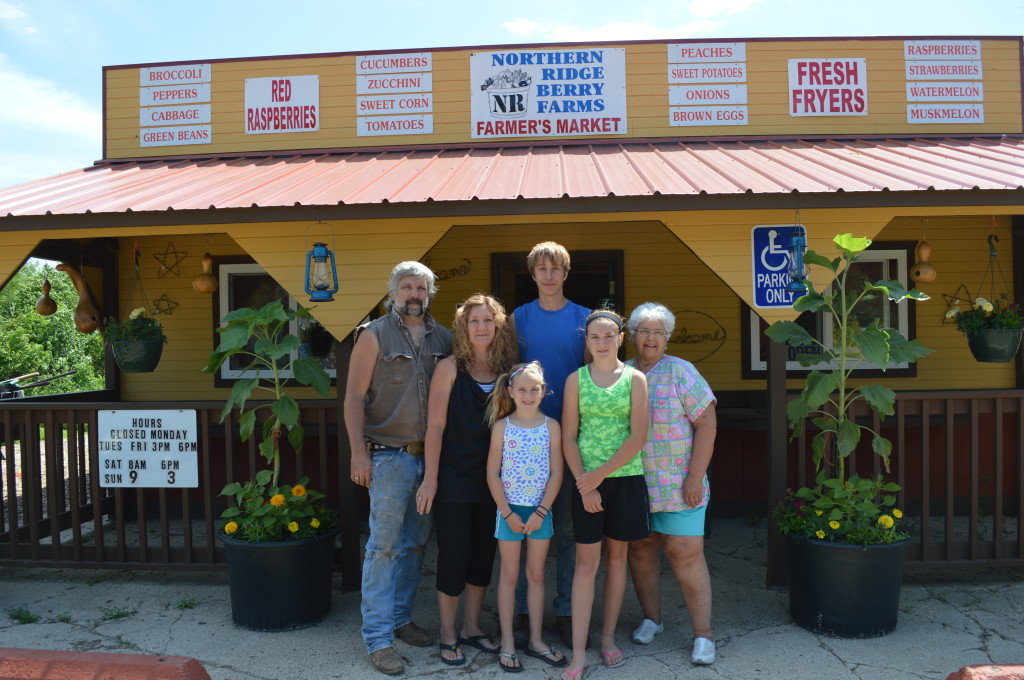 Members of the Lucina family stand in front of the market shop they've built at Northern Ridge Berry Farm, near Oxford, Iowa. (photo/Cindy Hadish)