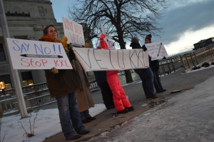 Opponents of the Keystone XL and Bakken pipelines hold signs Tuesday, Jan. 13, on the Third Avenue Bridge in downtown Cedar Rapids. (photo/Cindy Hadish)