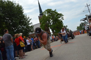 Spectators watch the "human tractor pull" in Chelsea, Iowa, during the town's sesquicentennial celebration in 2014. Chelsea is among the communities participating in a "Tama Town Mystery" this summer. (photo/Cindy Hadish)