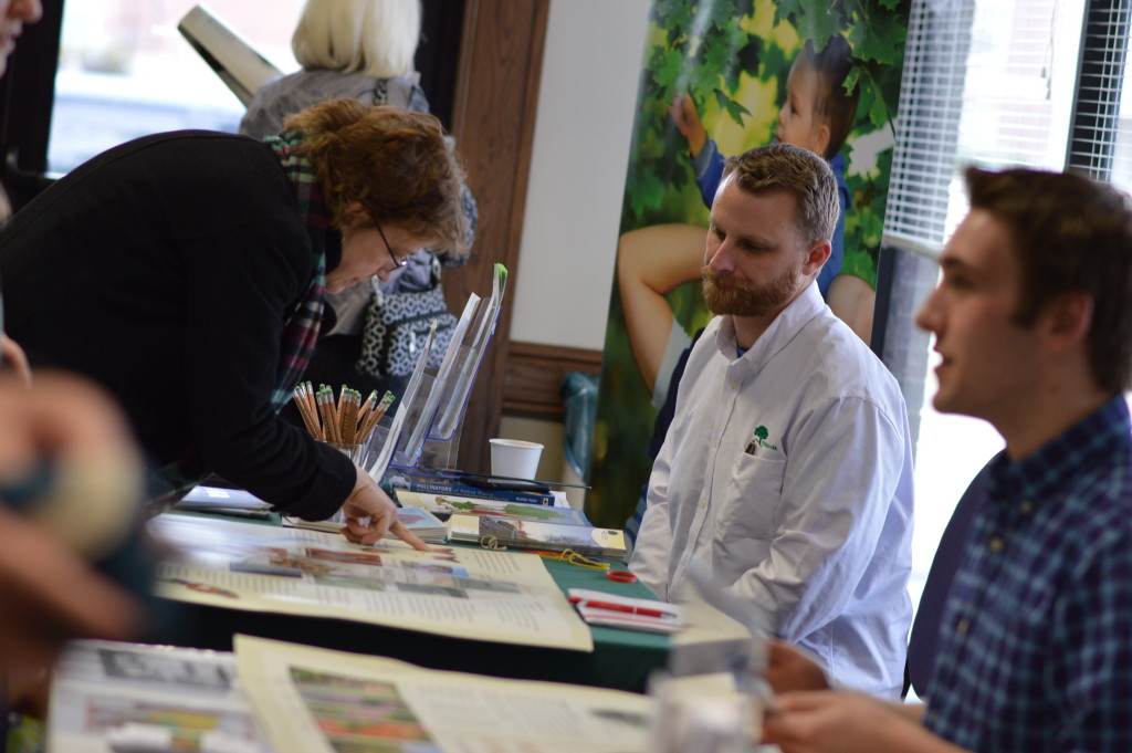 Dustin Hinrichs, (center) of Trees Forever, talks to visitors at the vendor booths during the Winter Gardening Fair in Cedar Rapids. (photo/Cindy Hadish)