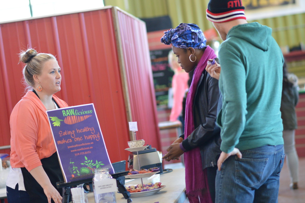 Jessica LaFayette, left, owner of Rawlicious, talks to customers during a sampling preview on Saturday, April 2, 2016, at NewBo City Market in Cedar Rapids. (photo/Cindy Hadish)
