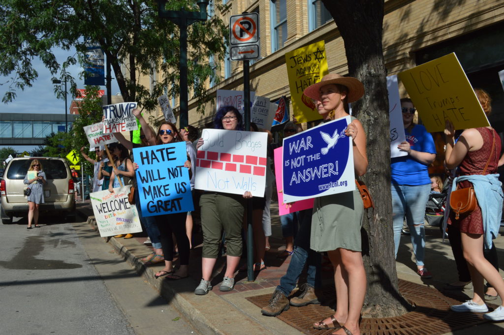 Signs promoting peace were among the messages at the protest outside of the Donald Trump rally. (photo/Cindy Hadish)