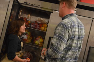  Lea Olson, board secretary for the Iowa Valley Food Co-op, talks to Marcus Johnson of Buffalo Ridge Orchard at the co-op's last distribution day on Nov. 2. The co-op is ending after a five-year run. (photo/Cindy Hadish) 